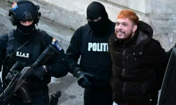 Le trafiquant de drogue français Mohamed Amra (c) escorté par des policiers hors de la Cour d'appel de Bucarest, le 23 février 2025, au lendemain de son arrestation en Roumanie