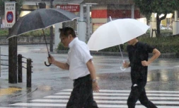 Des piétons sous la pluie à Tokushima au Japon, le 23 août 2018