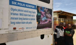 De hommes attendent devant un centre moblie de vaccination dans une rue de Mount Hagen en Papouasie-Nouvelle-Guinée, le 22 novembre 2018