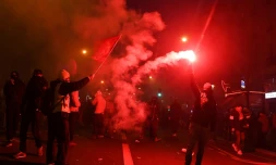 Un manifestant brandit une fusée rouge pendant la manifestation jeudi à Paris contre la réforme des retraites qui a vu des centaines de milliers de personnes descendre dans les rues