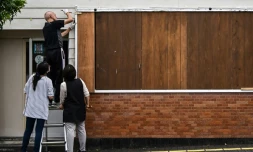 Un coiffeur barricade son salon avant le passage du typhon Jaishen, le 5 septembre 2020 à Makurazaki, dans le sud du Japon