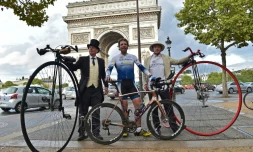 Le cycliste britannique Mark Beaumont (C) pose au côté de deux hommes et leur vélo grand-bi le 18 septembre 2017 à Paris