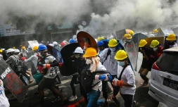 Des manifestants se protÚgent des tirs des forces de sécurité à l'aide de boucliers de fortune lors d'un rassemblement contre le coup d'Etat militaire, le 3 mars 2021 à Rangoun, en Birmanie