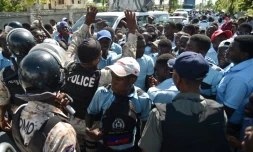 Des policiers haîtiens tentent de calmer des lycéens qui manifestent contre l'occupation de leur lycée Jean-Claudy Museau par des sinistrés de l'ouragan Matthew, le 16 novembre 2016 aux Cayes