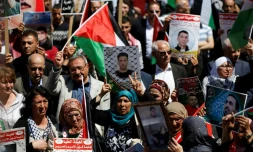 Des manifestants tiennent des photos de détenus palestiniens lors d'un rassemblement à Ramallah, le 17 avril 2017