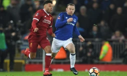 Le milieu de terrain de Liverpool Alex Oxlade-Chamberlain (g) poursuivi par le milieu d'Everton Wayne Rooney, lors des 32es de finale de la Coupe d'Angleterre, le 5 janvier 2018 à Anfield à Liverpool  