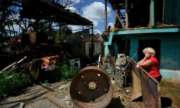 Une femme près de ce qu'il reste de sa maison après des frappes russes à Zalissia, dans la région de Kiev, le 22 juillet 2022
