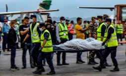 Des secouristes portent le corps d'une victime du crash d'un avion dans l'Himalaya, transporté par hélicoptère à Katmandou, le 30 mai 2022 au Népal