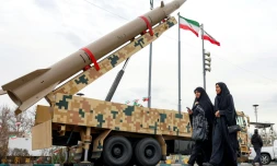 Des femmes passent devant un lanceur de missile balistique à Téhéran, le 11 février 2026, lors d'un rassemblement marquant le 47e anniversaire de la révolution islamique de 1979 en Iran