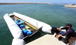 Des garde-côtes libyens ramènent un canot pneumatique contenant les corps de migrants après le naufrage de leur embarcation, le 10 juin 2017 au large de la ville de Garaboulli