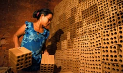 Une cambodgienne travaille dans une fabrique de briques dans la banlieue de Phnom Penh, le 11 décembre 2018