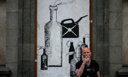 Le street artiste ukrainien Galmet Zinkovski devant son oeuvre à Kharkiv, dans l'est de l'Ukraine, le 16 mai 2022