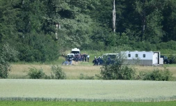 Jonathann Daval (C), entouré de gendarmes, le 17 juin 2019, lors de la reconstitution du meutre d'Alexia Daval, aux abords du bois d'Esmoulins où son corps avait été retrouvé.