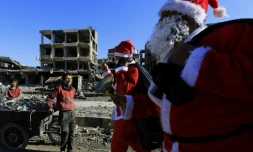 Deux pères Noël distribuent des cadeaux à Raqa, l'ancien fief du groupe Etat islamique (EI) en Syrie encore ravagée par les combats, le 26 décembre 2017