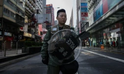 Une femme de la police anti-émeutes de Hong Kong le 9 février 2016 devant une rue interdite d'accès après les heurts de la nuit entre la police et des protestataires dans le quartier de Mongkok à Hong Kong le 9 février 2016 