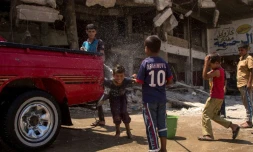 Des enfants irakiens lavent une voiture à Mossoul, le 12 juillet 2017