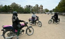L'instructrice Shafaq Zaman (c) apprend à conduire une moto aux femmes du groupe "Rowdy Riders", le 5 mars 2024 à Karachi, au Pakistan