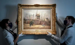 Des employés mettent en place l'oeuvre du peintre néerlandais Vincent Van Gogh "ScÚne de rue à Montmartre" (1887) au sein de la maison d'enchÚres Sotheby's à Paris le 24 février 2021