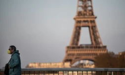 Un homme portant un masque de protection traverse le pont de Grenelle, le 18 mars 2020 à Paris, au lendemain du confinenemnt instauré en France pour lutter contre le coronavirus