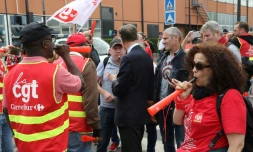 Un actionnaire quittant l'assemblée générale de Carrefour le 15 juin 2018 à Aubervilliers (Seine-Saint-Denis) parle avec des syndicalistes CGT