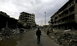 Un membre des "Forces démocratiques syriennes" marche au milieu des décombres dans une rue de Raqa, en Syrie, le 28 octobre 2017