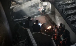 Des habitants et secouristes fouillent un immeuble touché par une frappe israélienne dans le quartier Shoujaiya de Gaza-ville, le 10 avril 2025