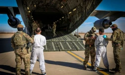 Photo diffusée par le ministère américain de la Sécurité intérieure montrant l'embarquement de migrants détenus sur un vol à destination de la base navale de Guantanamo, depuis un lieu non précisé aux États-Unis, le 4 février 2025