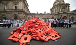 Un collectif de bénévoles d'aide aux migrants a déversé des gilets de sauvetage devant le Sénat pour alerter sur les naufrages en mer et protester contre le projet de loi asile-immigration, le 19 juin 2018 à Paris