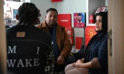 Uzma Naveed, coordinatrice, et Jeffrey Andrews, travailleur social, parlent à "John" dans un bureau de Centre d'action chrétien pour les réfugiés à Hong Kong