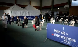 Des personnes attendent de se faire vacciner dans un gymnase Ă Valenciennes le 23 mars 2021