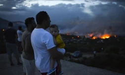 Des Grecs observent un feu de forêt à Rafina dans la banlieue d'Athènes, en Grèce