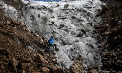 Le guide de randonnée Charles Kibaki Muchiri observe le paysage, assis au pied du glacier Lewis, près du sommet du mont Kenya, dans le parc national du mont Kenya, le 7 mars 2025