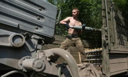 Un soldat ukrainien charge une batterie de roquettes près d'Izyum, au sud de Kharkiv, le 11 juin 2022 dans l'est de l'Ukraine