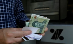 Un homme retire des rials iraniens d'un distributeur à Téhéran, le 31 juillet 2018