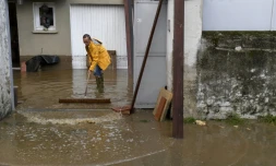 Un homme nettoie la boue devant sa maison à Anduze, le 19 septembre 2020