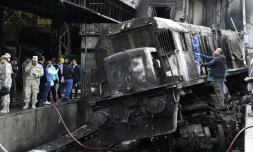 Des membres des forces de sécurité et des passants se tiennent sur un quai en gare du Caire après un accident de train ayant provoqué un incendie le 27 février 2019