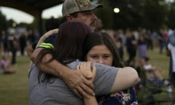 Une famille lors de la veillée en hommage aux victimes des tirs du lycée Apalachee de Winder, en Géorgie (sud-est des Etats-Unis), le 4 septembre 2024