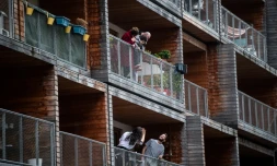 Discussion entre voisins depuis leur balcon, à Paris le 20 mars 2020