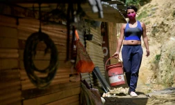 Yeimy Martinez porte un seau d'eau pour cuisiner, le 26 mai 2020 Ă Bogota, en Colombie