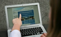 Une femme montre le site Web du NHS (East and North Hertfordshire), informant les utilisateurs d'un problème dans son réseau, à Londres le 12 mai 2017