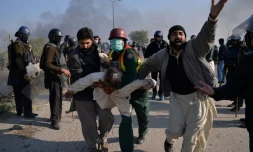 Des manifestants islamistes pakistanais évacuent l'un des leurs blessé lors d'affrontements avec la police samedi 25 novembre 2017 à Islamabad