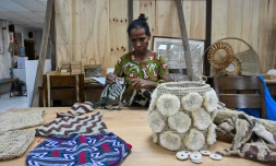 Une femme fabrique un sac "bilum" traditionnel dans un atelier à Port Moresby, le 19 mai 2023 en Papouasie-Nouvelle-Guinée