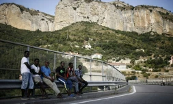 Des migrants attendent au bord d'une route dans la vallée de la Roya, près de Vintimille à la frontière franco-italienne, le 8 août 2017
