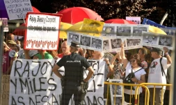Un policier devant des manifestants qui attendent l'arrivée du chef du gouvernement Mariano Rajoy, entendu comme témoin dans un procès pour corruption, le 26 juillet 2017 à San Fernando de Henares, près de Madrid