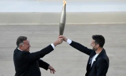 Le président du comité olympique hellénique Spyros Capralos (à gauche) remet la flamme olympique au président du Comité d'organisation des JO-2024 de Paris Tony Estanguet lors d'une cérémonie à AthÚnes le 26 avril 2024