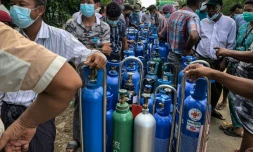 Des gens attendent pour remplir des bouteilles d'oxygène pour leurs proches atteints de Covid-19, à Rangoun le 14 juillet 2021
