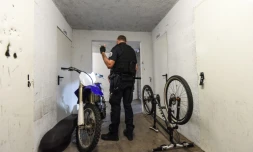 Un policier inspecte une moto dans la cave d'un immeuble dans le cadre d'une opération anti-rodéos urbains, le 11 août 2022 à Nantes