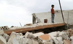 Un enfant au milieu des ruines d'un bâtiment dans le village de Rabaa Jour, situé dans l'ultime bastion jihadiste du nord-ouest de la Syrie, le 6 mai 2019