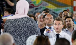 Le président français Emmanuel Macron (d) parle à une mère dans le public présent dans un gymnase du quartier marseillais de La Busserine, le 26 juin 2023