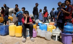 Des Palestiniens attendent de pouvoir obtenir de l’eau dans un camp de personnes déplacées à Gaza-Ville, le 20 mai 2025, sur fond de guerre entre Israël et le mouvement palestinien Hamas